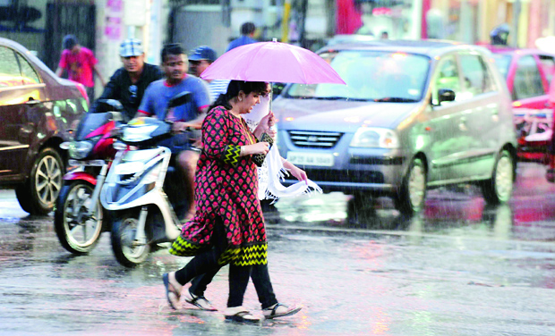 People walk in the rain on Tuesday evening in Hyderabad (Photo: DC) People walk in the rain on Tuesday evening in Hyderabad (Photo: DC)